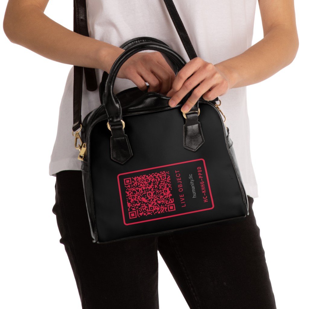 Model holding founding LIVE OBJECT purse by top handles